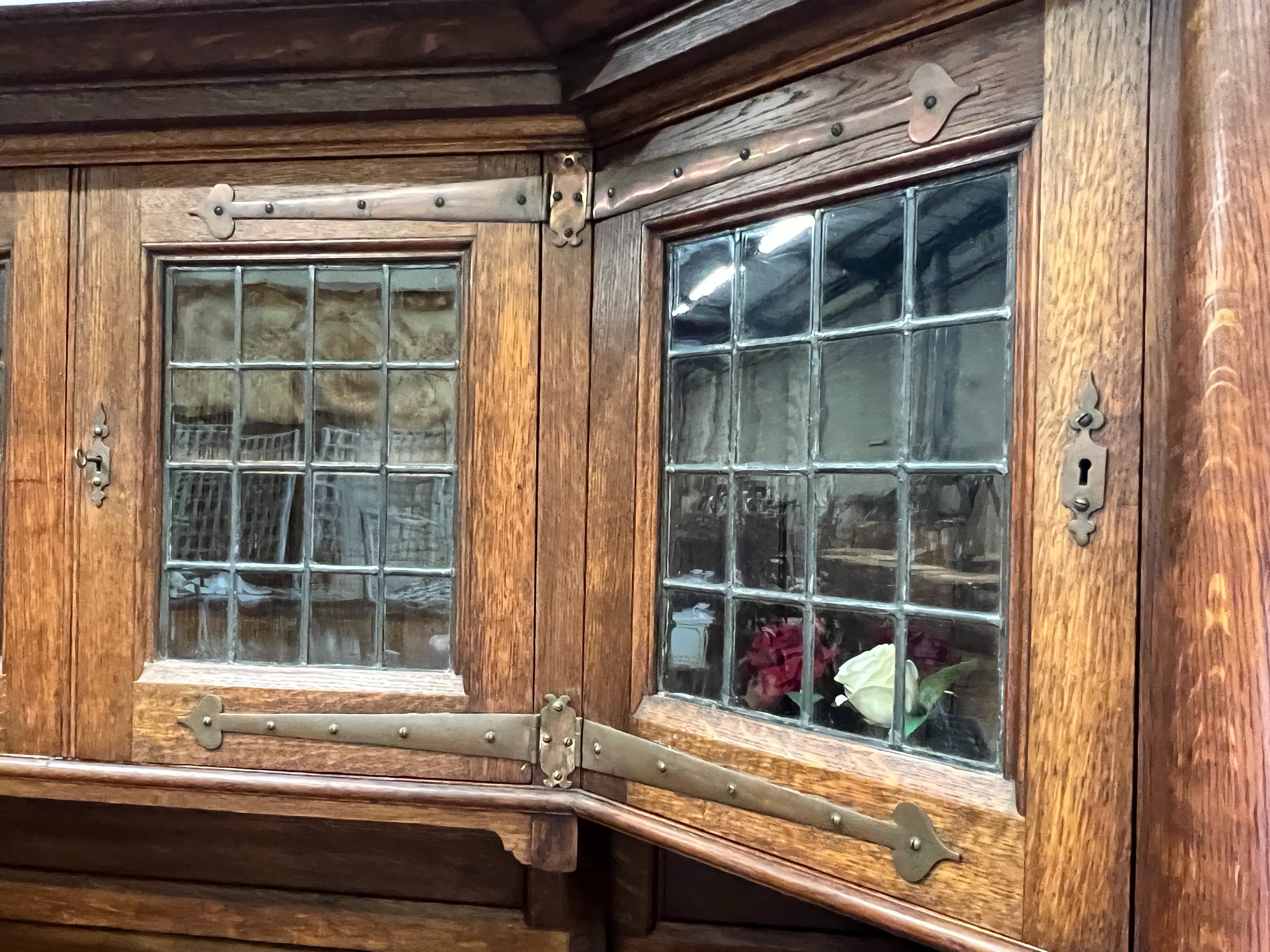 An early 20th century Arts & Crafts copper mounted oak sideboard in the manner of Shapland and Petter, stamped Warings, Oxford Street, London, length 168cm, width 64cm, height 180cm